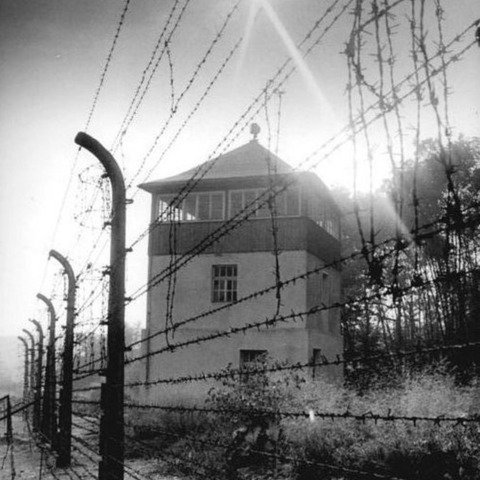 Historische foto van een wachtoren en het omringende staaldraadheg van het voormalige nazi-concentratiekamp Buchenwald.