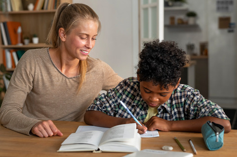Front view woman helping kid with homework